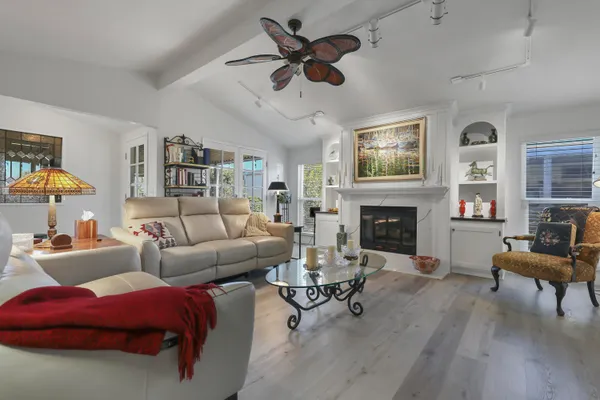 a living room with furniture a fireplace and a flat screen tv