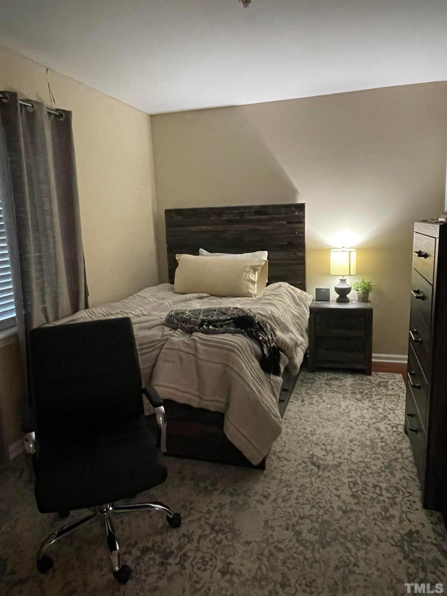 720 Bilyeu Street, Unit 203 Raleigh, NC 27606 - Photo 11 of 13 a bedroom with a bed and a refrigerator