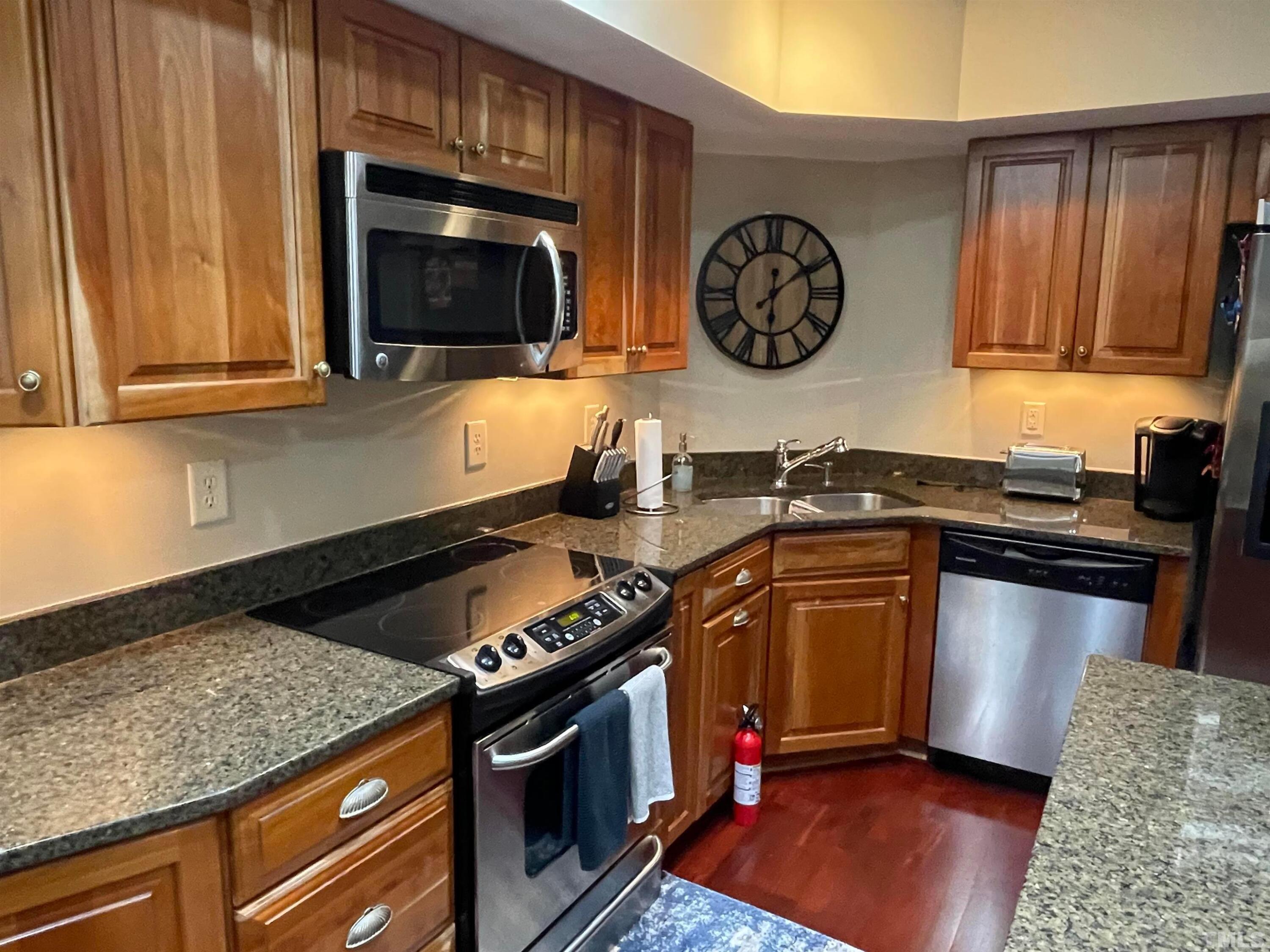 720 Bilyeu Street, Unit 203 Raleigh, NC 27606 - Photo 4 of 13 a kitchen with stainless steel appliances granite countertop a stove and a microwave