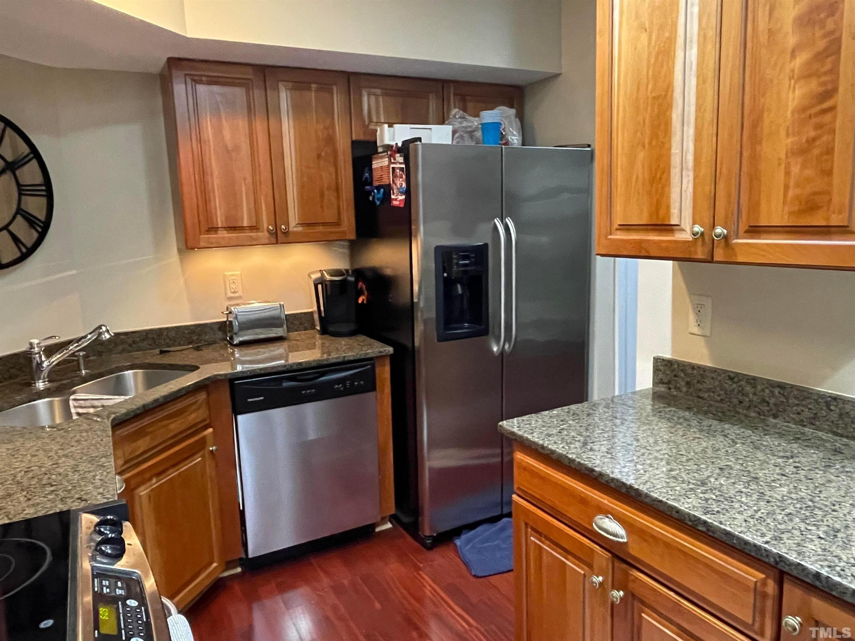720 Bilyeu Street, Unit 203 Raleigh, NC 27606 - Photo 6 of 13 a kitchen with granite countertop a refrigerator and a stove