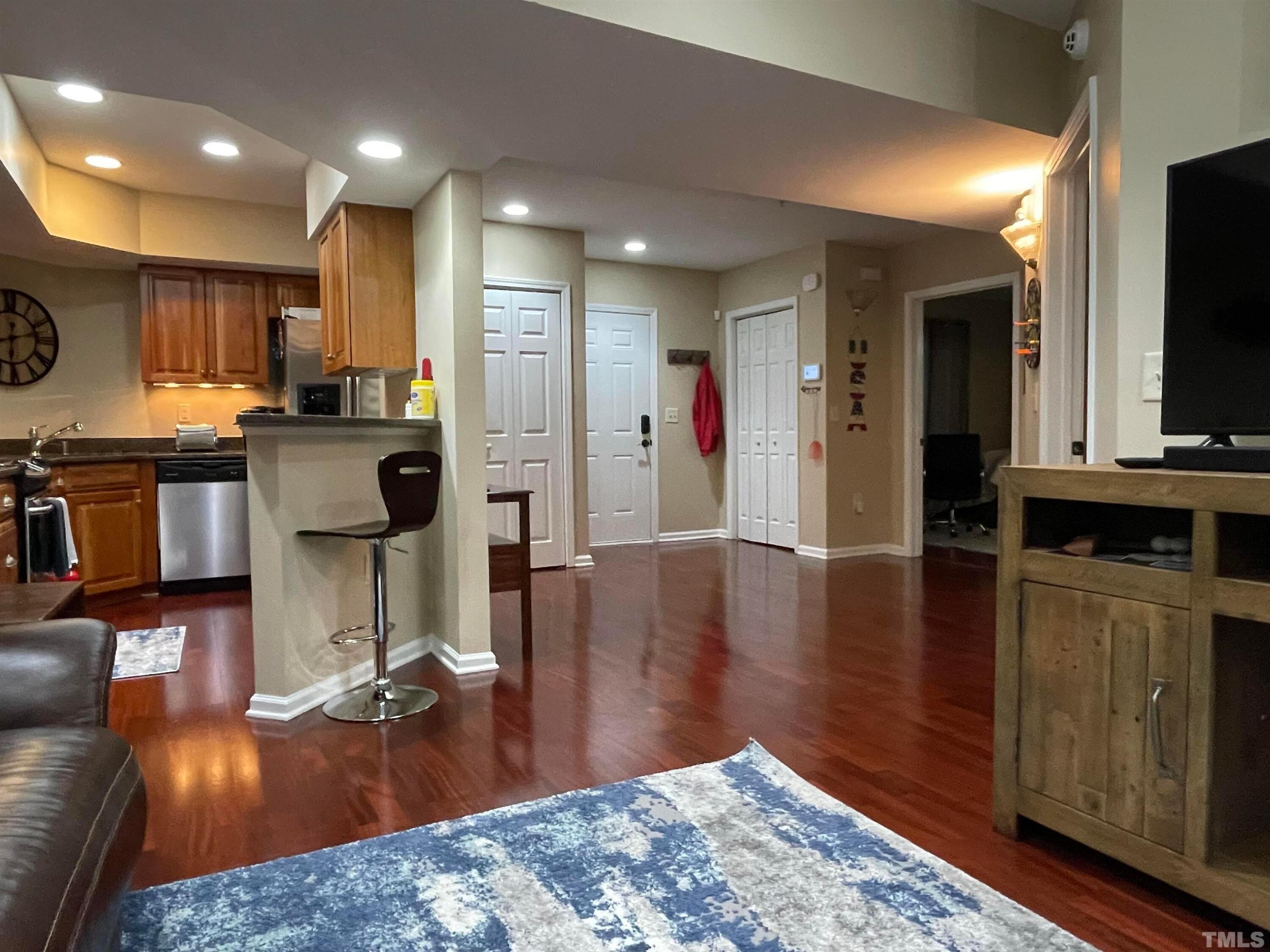 720 Bilyeu Street, Unit 203 Raleigh, NC 27606 - Photo 7 of 13 a view of a living room and kitchen with furniture wooden floor and a fireplace