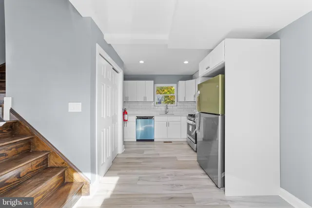 a view of a kitchen with refrigerator and a stove