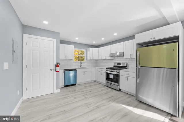 a kitchen with stainless steel appliances granite countertop a refrigerator sink and stove