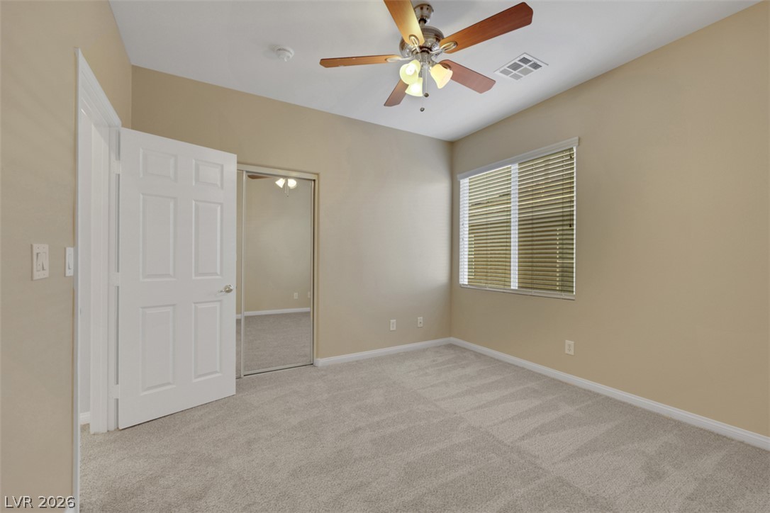 10328 Hawk Ravine Street Las Vegas, NV 89178 - Photo 31 of 55 A comfortable bedroom with soft carpeting and a bright window, offering a peaceful retreat.