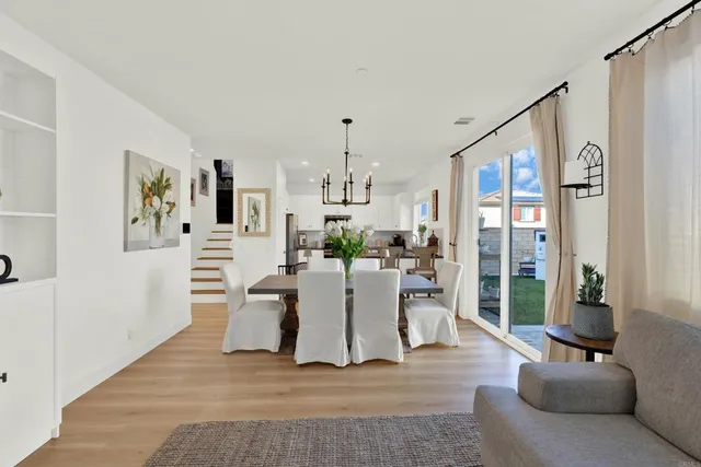 a living room with furniture a large window and a dining table