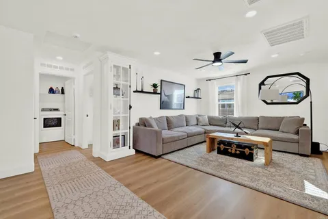 a living room with furniture and a ceiling fan