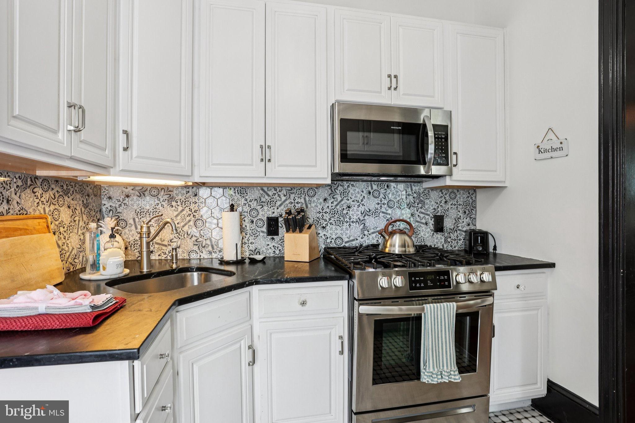 414 Broadway Cape May, NJ 08204 - Photo 37 of 48 a kitchen with stainless steel appliances wooden cabinets and a stove top oven