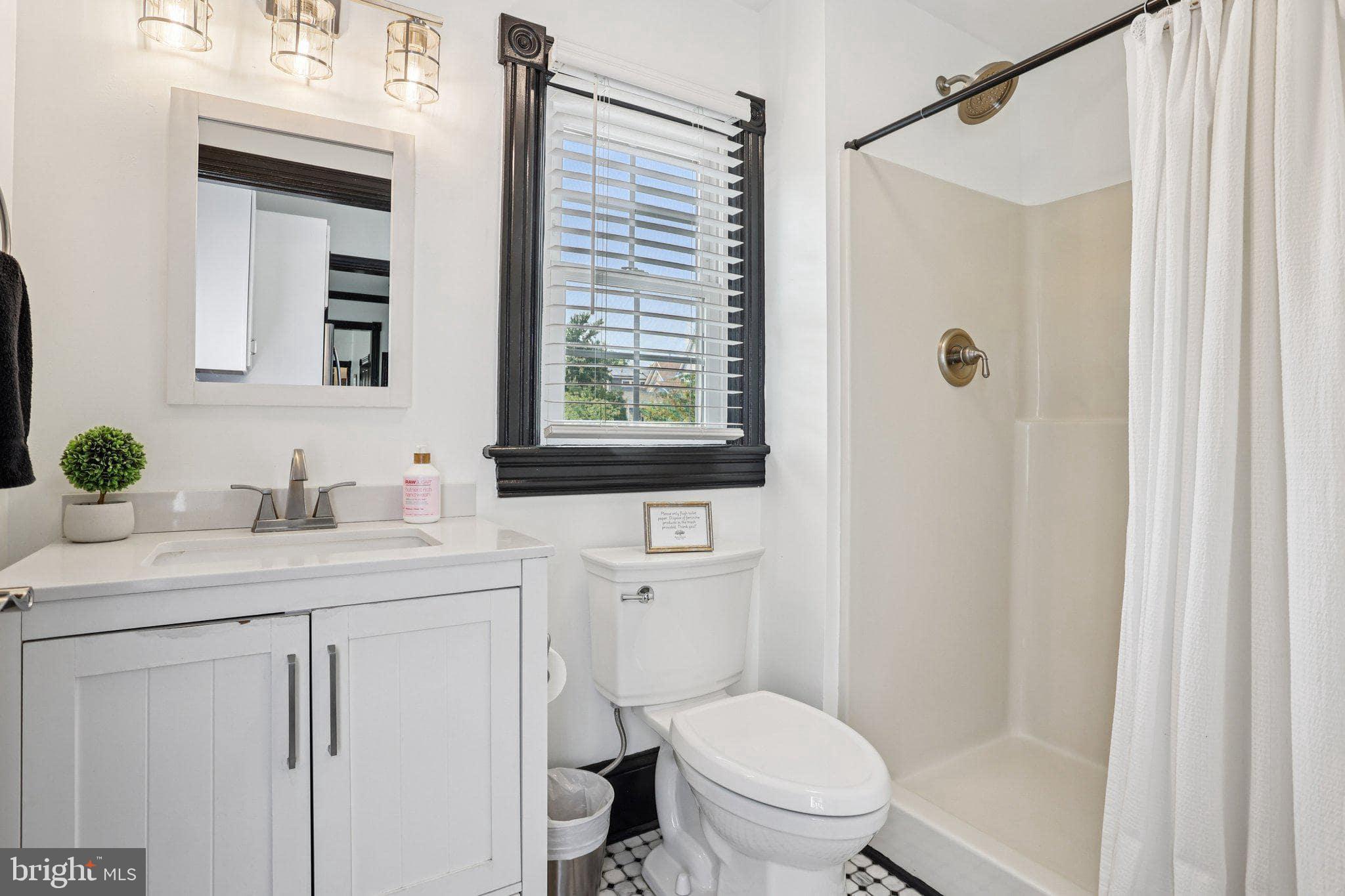 414 Broadway Cape May, NJ 08204 - Photo 38 of 48 a bathroom with a granite countertop sink toilet a mirror and shower