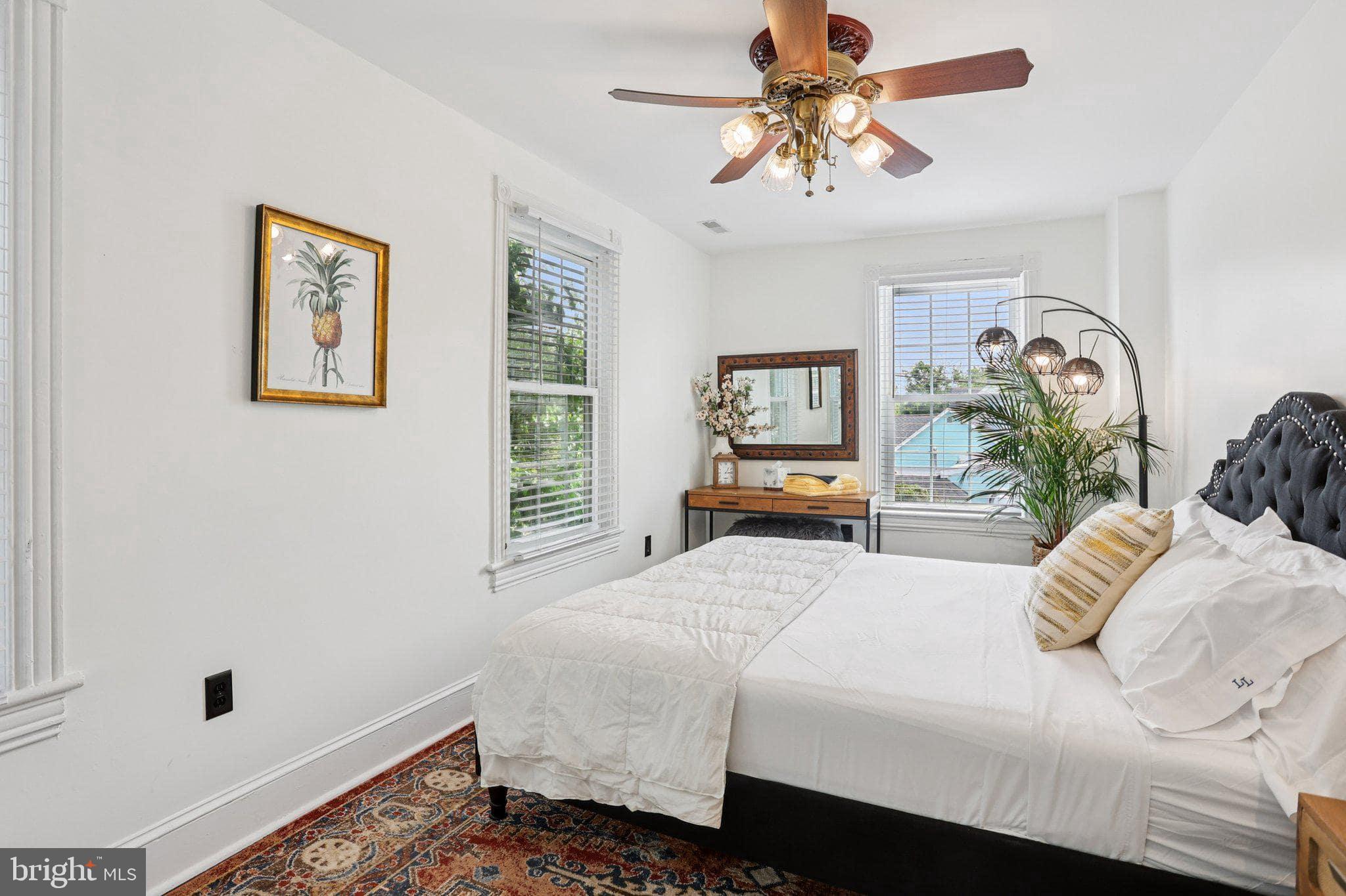 414 Broadway Cape May, NJ 08204 - Photo 41 of 48 a bedroom with a bed and a chandelier