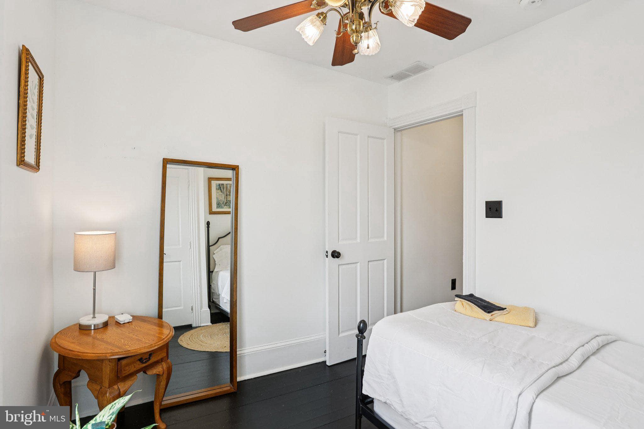 414 Broadway Cape May, NJ 08204 - Photo 48 of 48 a bedroom with a bed and a chandelier