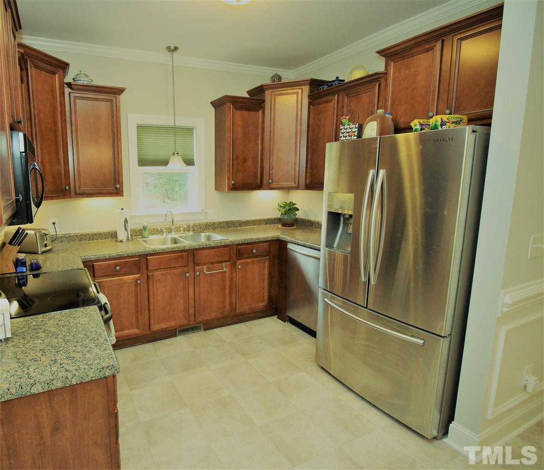 8808 Oregon Inlet Court Raleigh, NC 27603 - Photo 6 of 19 a kitchen with stainless steel appliances granite countertop a refrigerator a sink and a stove