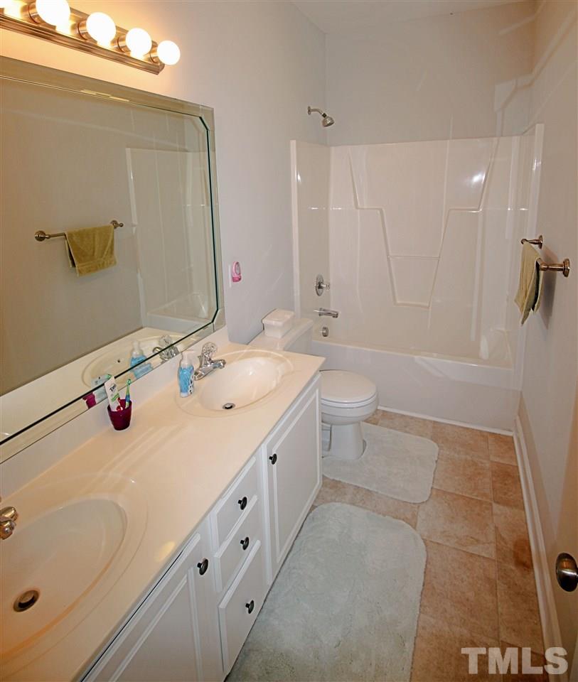 8808 Oregon Inlet Court Raleigh, NC 27603 - Photo 10 of 19 a bathroom with a double vanity sink toilet mirror and shower
