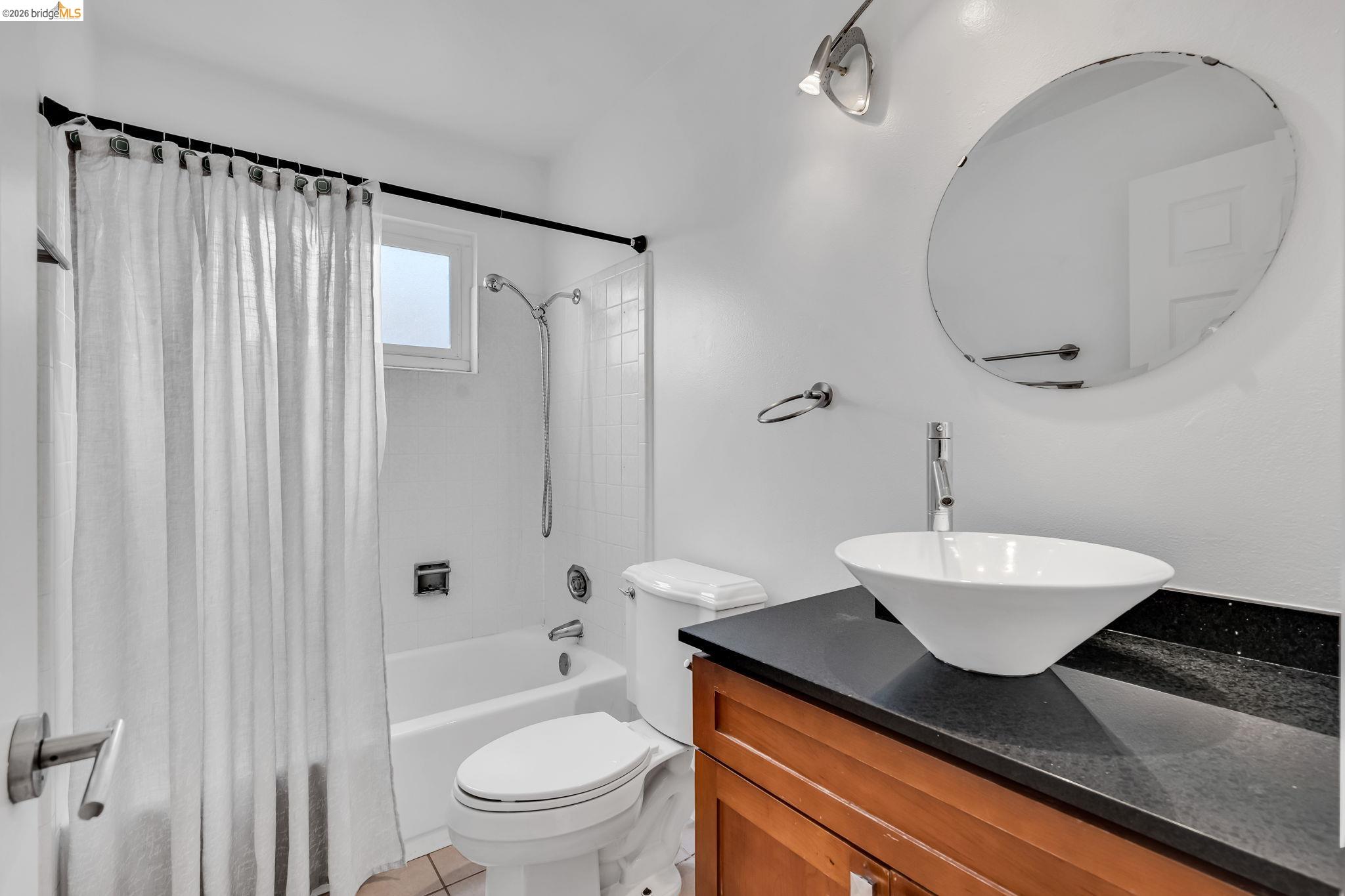 909 Halite Way Antioch, CA 94509 - Photo 14 of 52 a bathroom with a granite countertop sink toilet a mirror and shower