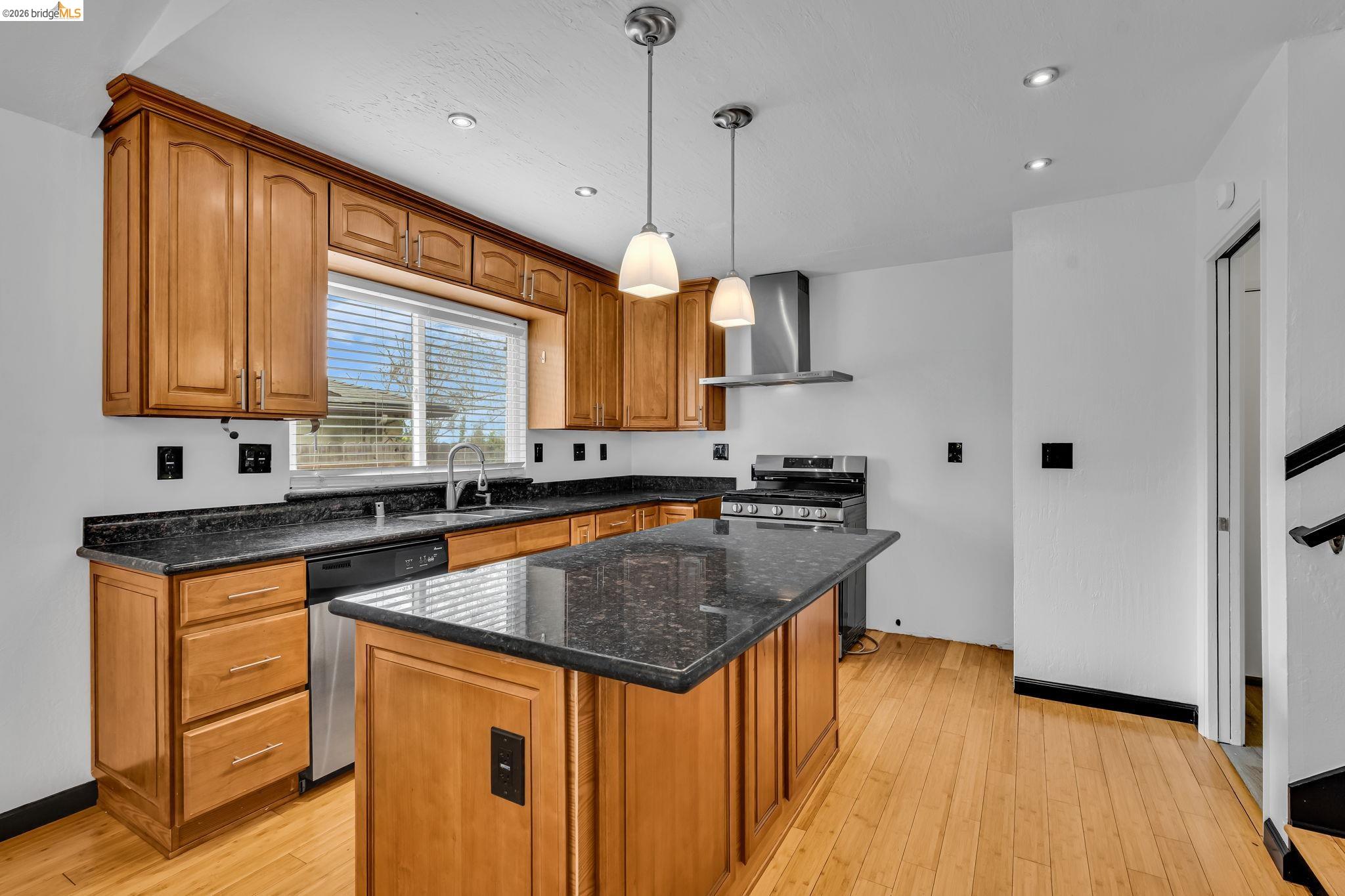 909 Halite Way Antioch, CA 94509 - Photo 25 of 52 a kitchen with stainless steel appliances granite countertop a sink a stove and a wooden floor