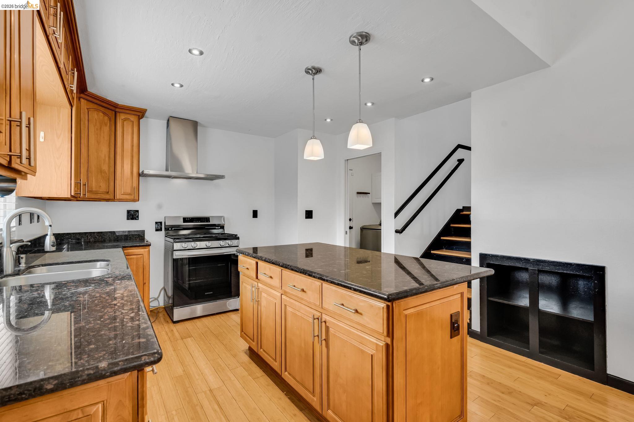 909 Halite Way Antioch, CA 94509 - Photo 26 of 52 a kitchen with granite countertop a sink a stove and oven with wooden floor