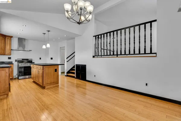 a kitchen with granite countertop stainless steel appliances a stove top oven a sink and cabinets