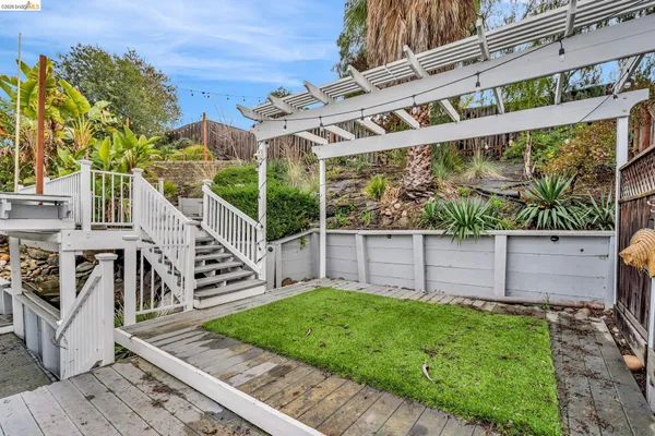 a view of a house with a small yard and wooden fence