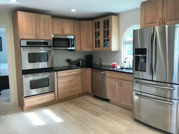 a kitchen with granite countertop a refrigerator stove and microwave