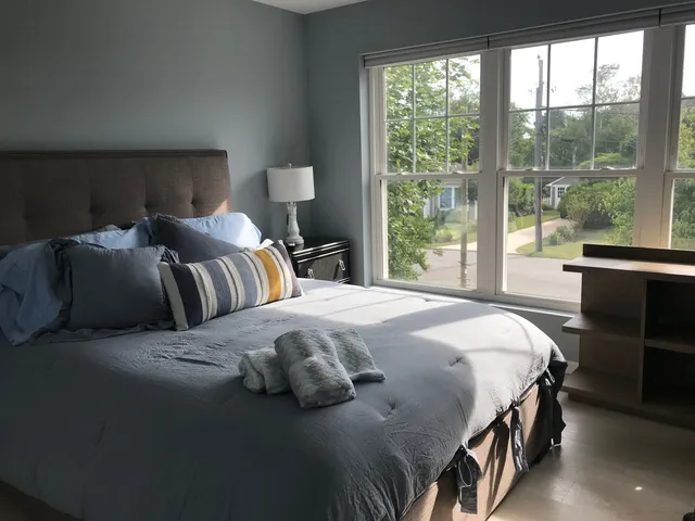 a bedroom with a bed and a large window