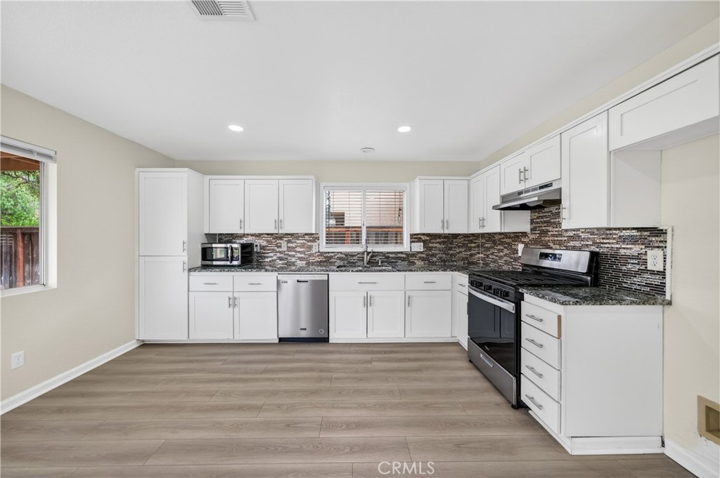 43425 Corte Logrono Temecula, CA 92592 - Photo 12 of 49 a kitchen with granite countertop white cabinets and white appliances