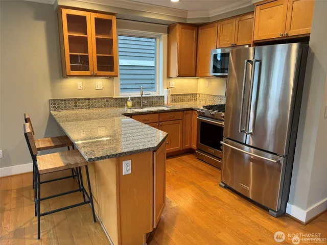 a kitchen with stainless steel appliances granite countertop a refrigerator a stove and a sink