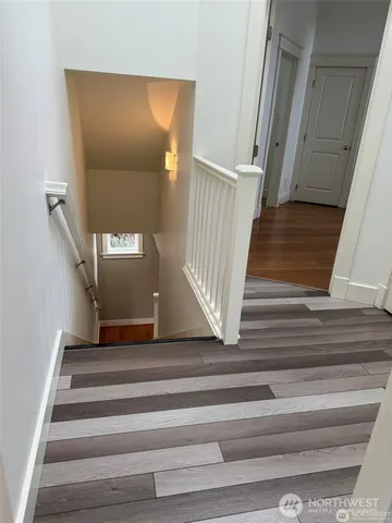 a view of staircase with white walls and railing