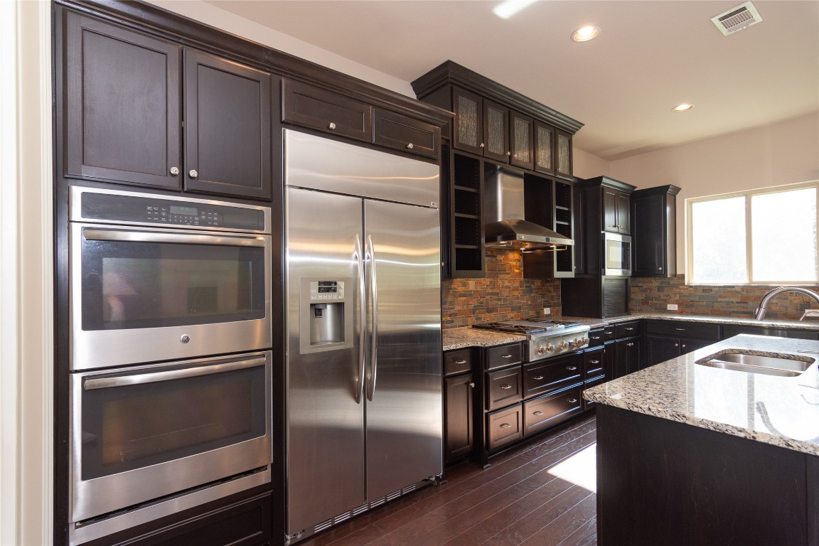 316 Chadwick Drive Georgetown, TX 78628 - Photo 13 of 39 a kitchen with granite countertop stainless steel appliances and wooden cabinets