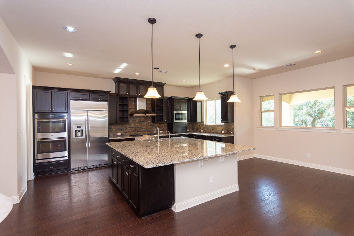 316 Chadwick Drive Georgetown, TX 78628 - Photo 9 of 39 a large kitchen with stainless steel appliances granite countertop a sink a counter space and wooden floor