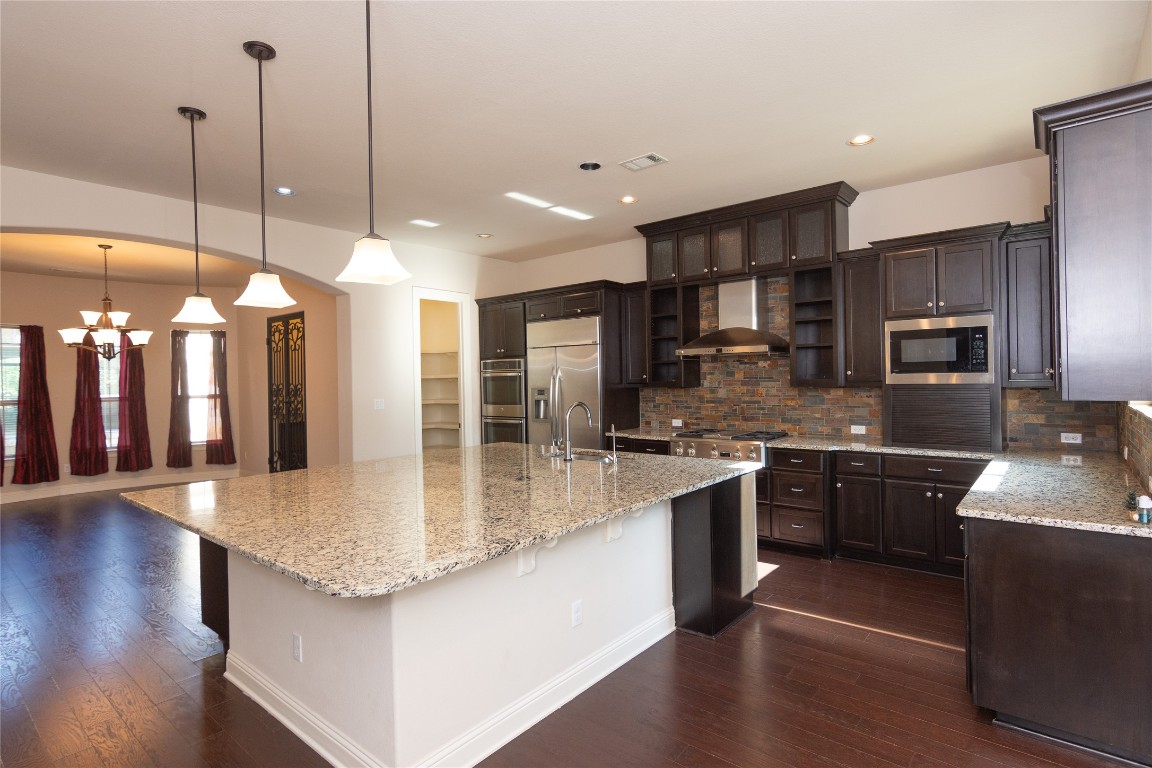 316 Chadwick Drive Georgetown, TX 78628 - Photo 10 of 39 a large kitchen with granite countertop a large kitchen island and a sink stainless steel appliances