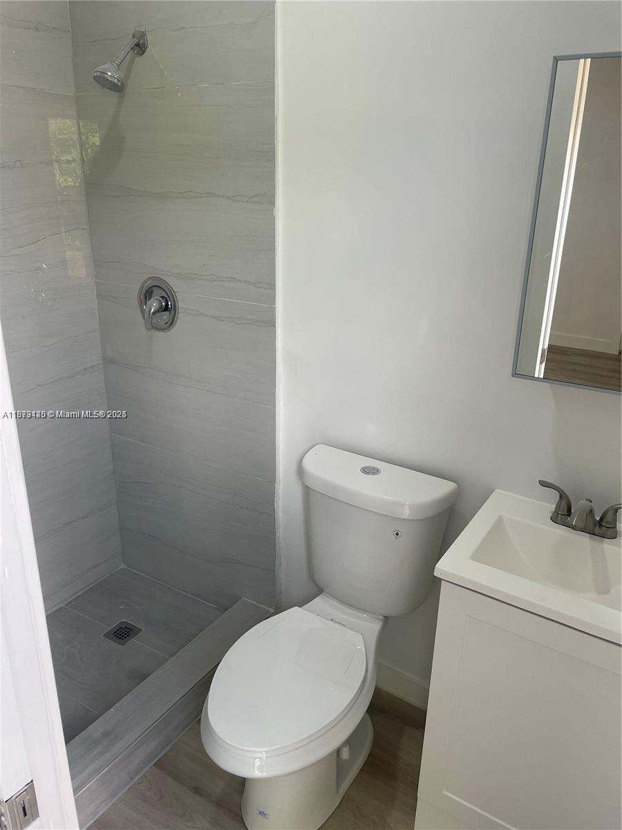 a white toilet sitting next to a shower