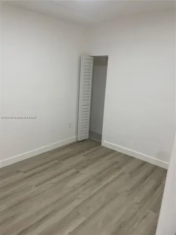 an empty room with wooden floor and closet