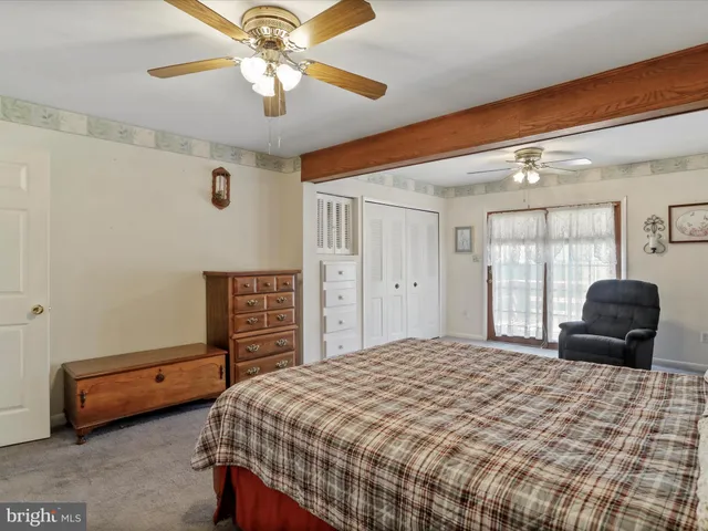 a bedroom with a bed closet and a ceiling fan