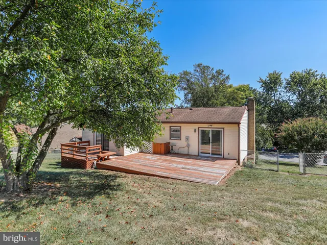 a backyard of a house with table and chairs under an umbrella