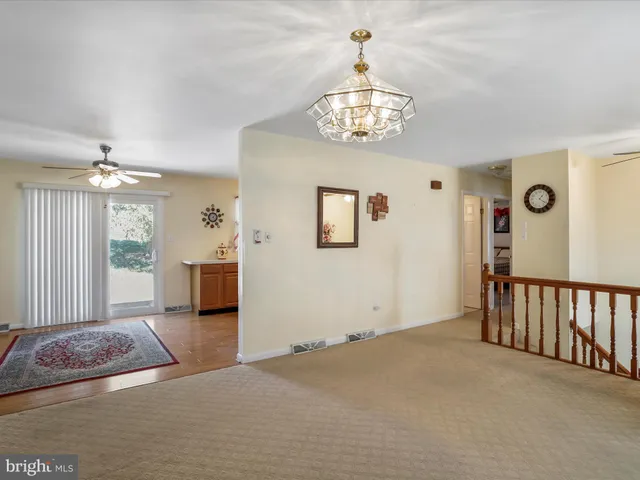 a view of a livingroom with wooden floor and chandelier