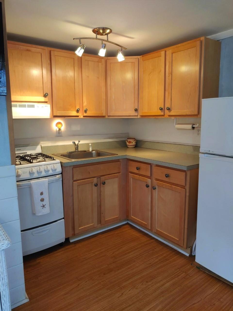 633 Route 6, Unit 3 Wellfleet, MA 02667 - Photo 7 of 9 a kitchen with a sink stove and cabinets