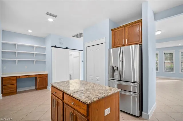 a kitchen with stainless steel appliances granite countertop a refrigerator and a stove top oven