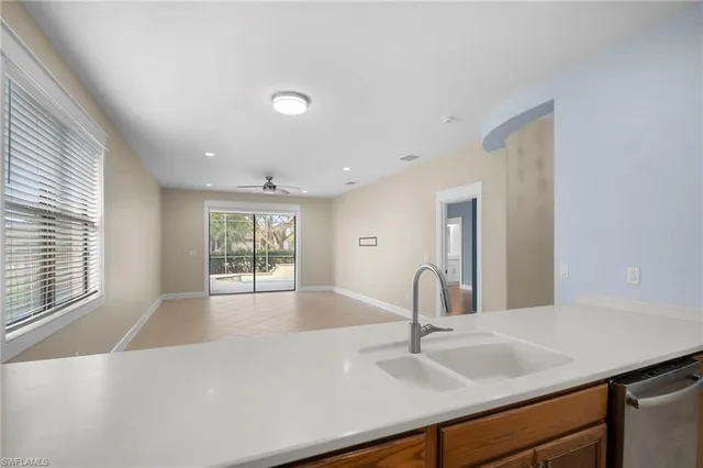 a large white kitchen with sink and window