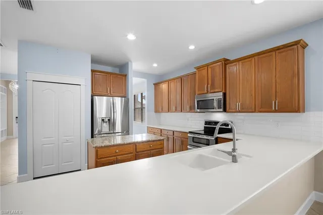 a kitchen with stainless steel appliances granite countertop a refrigerator sink and stove