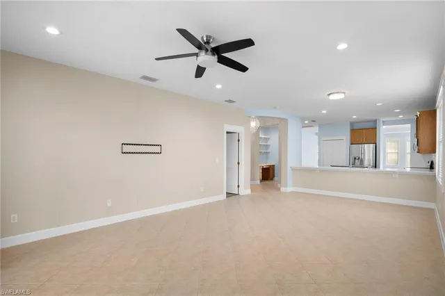 a view of a livingroom with a ceiling fan and kitchen space