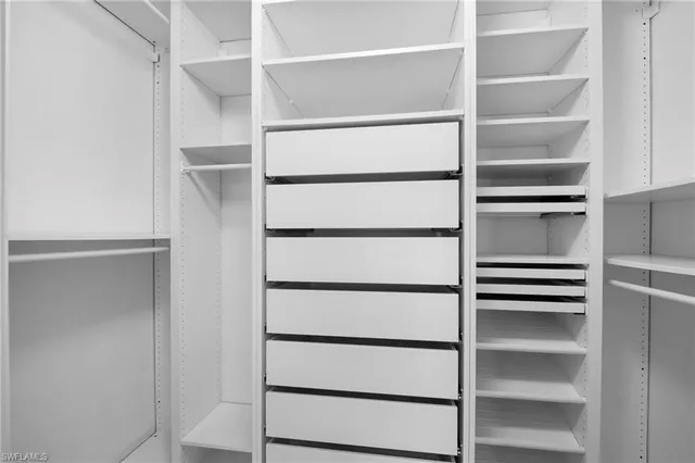 a view of walk in closet with empty racks