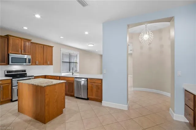 a kitchen with stainless steel appliances granite countertop a stove top oven a sink and a refrigerator