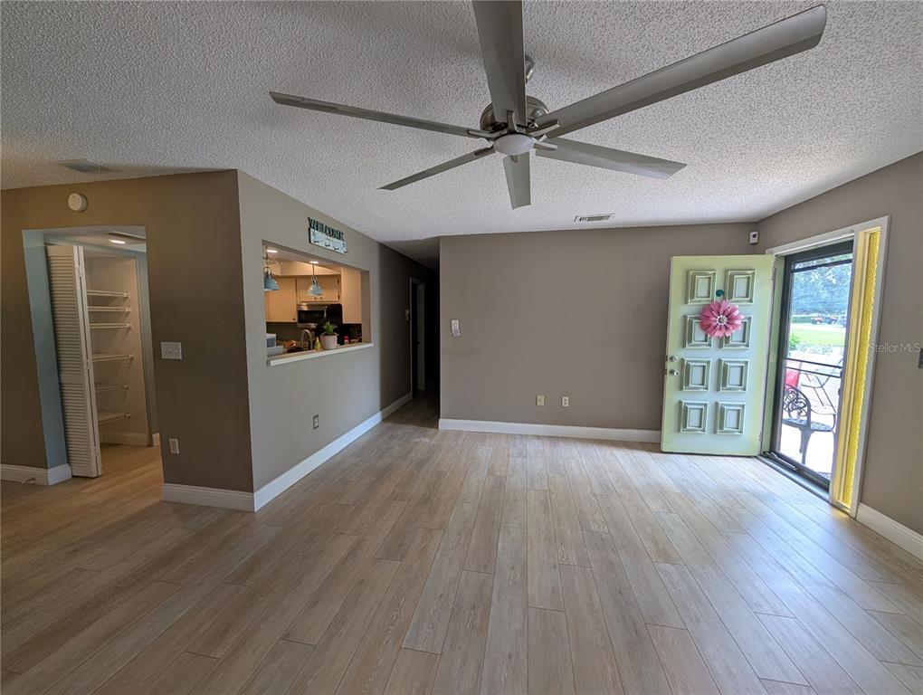 8161 Braddock Circle, Unit 1 Port Richey, FL 34668 - Photo 6 of 27 a view of a livingroom with wooden floor ceiling fan and windows