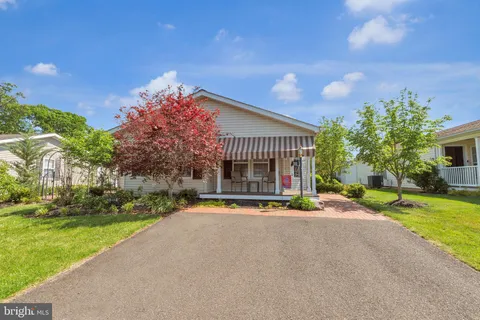 a view of a house with a yard and potted plants