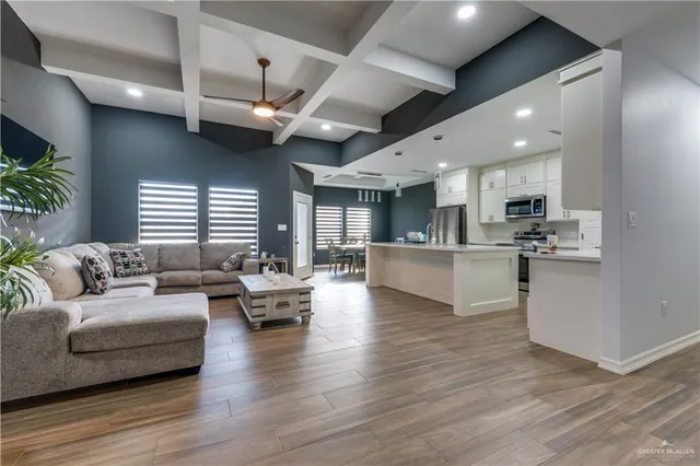 a living room with furniture kitchen and a wooden floor