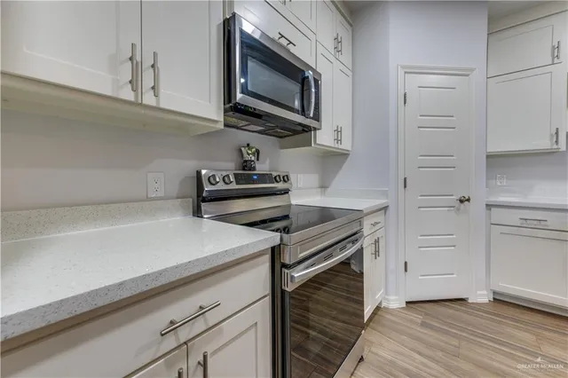 a kitchen with stainless steel appliances a stove microwave and cabinets