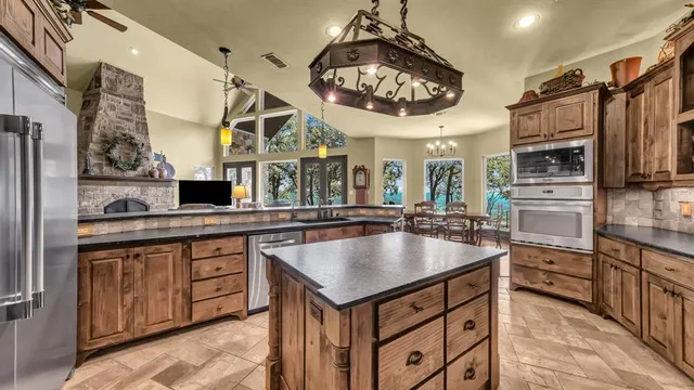 a kitchen with stainless steel appliances granite countertop a sink and a refrigerator