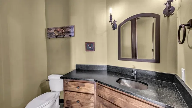 a view of a living room and kitchen with furniture a fireplace and wooden floor