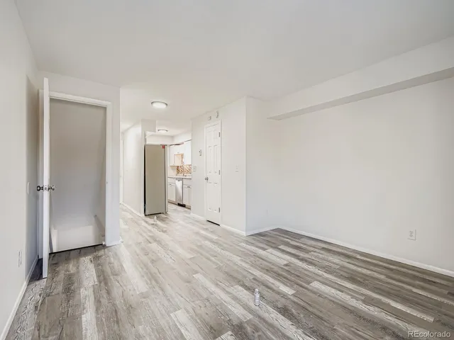a view of empty room with wooden floor