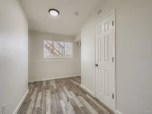 a view of a room with wooden floor and windows