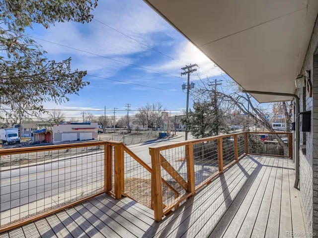 a view of a balcony with wooden floor and potted plants